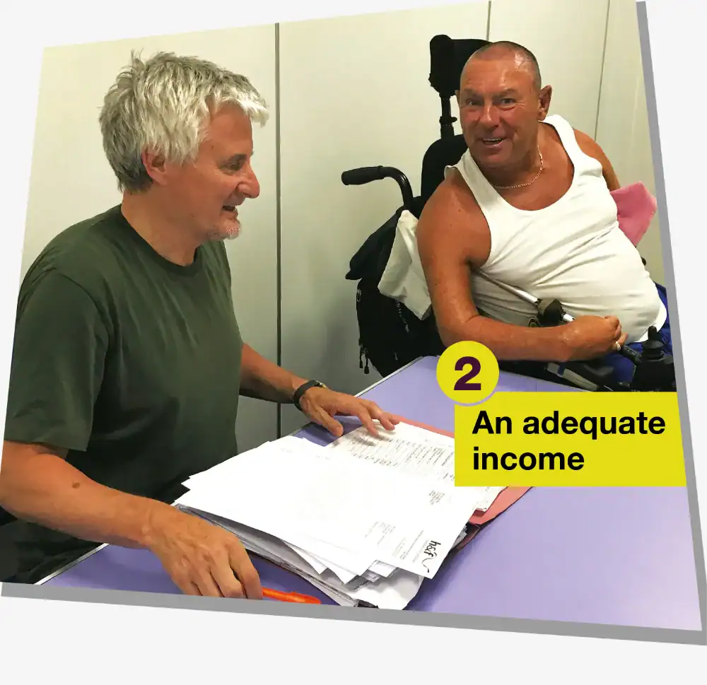 Two men sit at a table with paperwork; one is in a wheelchair. A label reads number 2 "An adequate income".