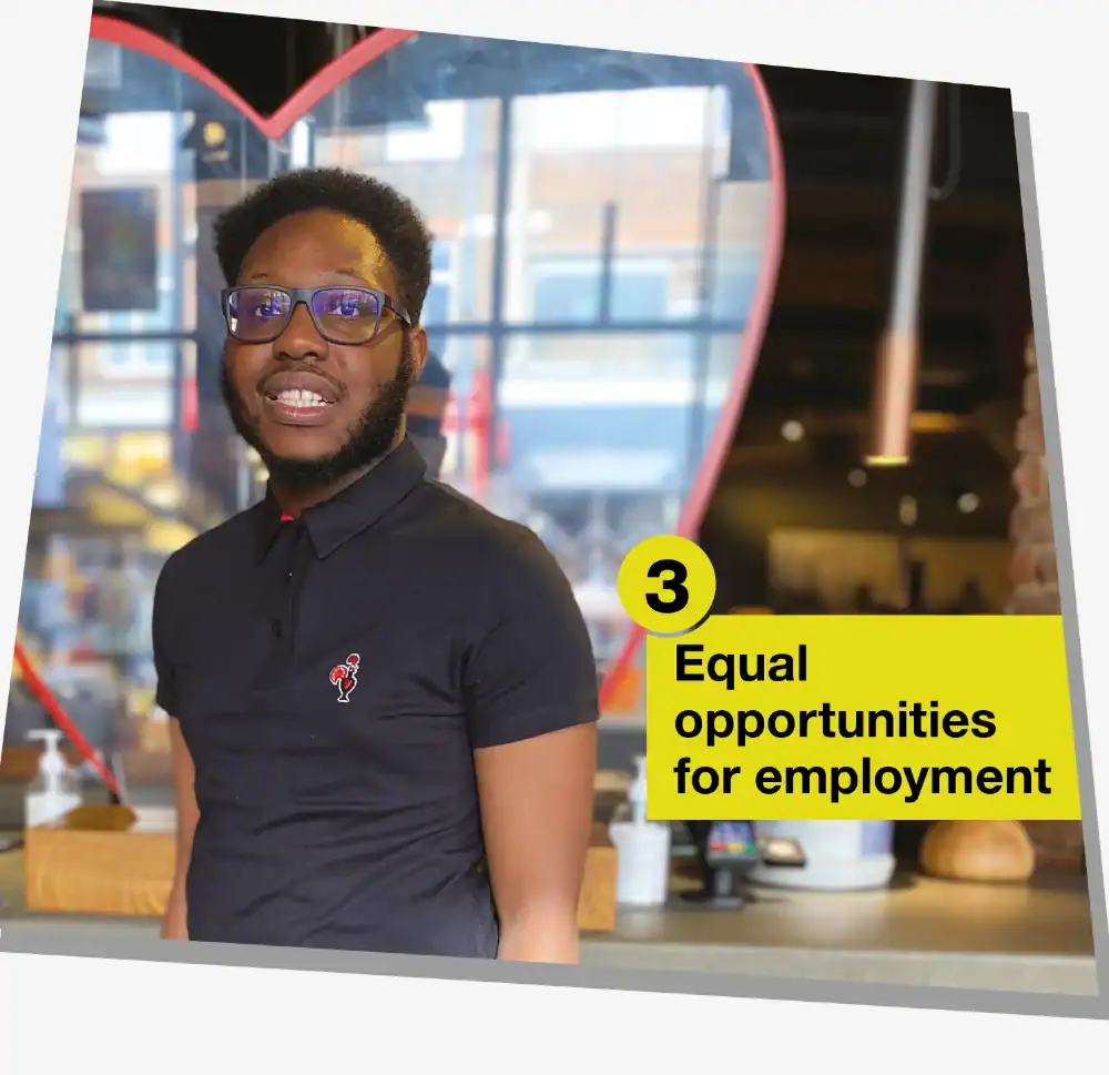 A man in a black polo shirt stands indoors with a heart shape behind him. A yellow box reads "3 Equal opportunities for employment.
